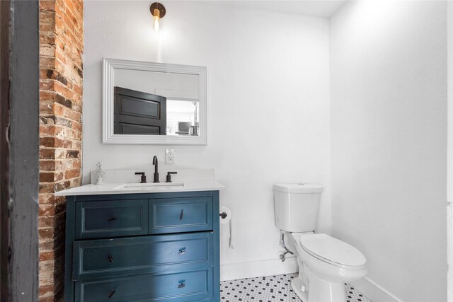 bathroom featuring toilet, baseboards, and vanity