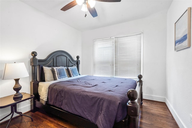 bedroom featuring baseboards, wood finished floors, and a ceiling fan