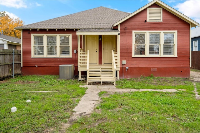view of front of home with central AC unit, roof with shingles, and crawl space