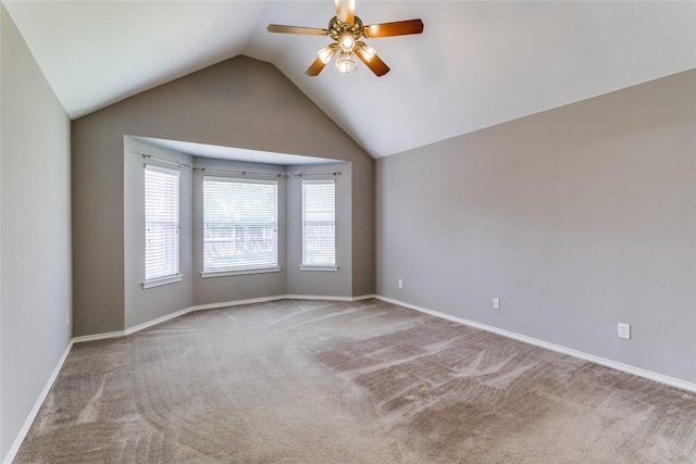empty room featuring carpet flooring, a ceiling fan, vaulted ceiling, and baseboards