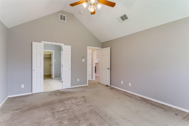 unfurnished bedroom with high vaulted ceiling, light colored carpet, a spacious closet, baseboards, and a ceiling fan