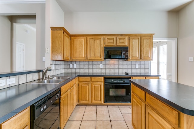 kitchen featuring black appliances, dark countertops, a sink, and backsplash