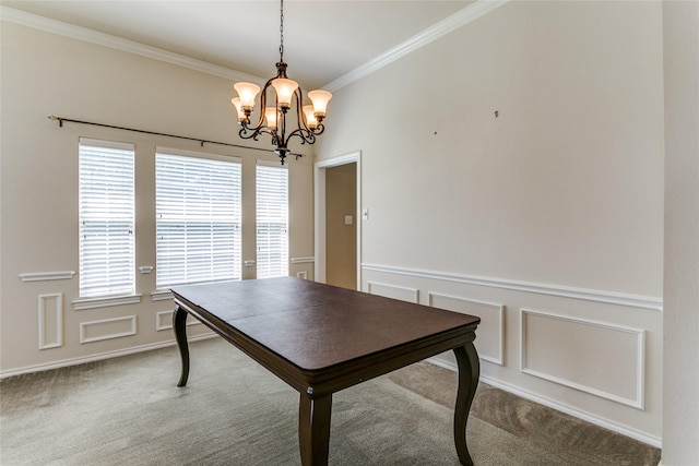 dining space featuring a chandelier, ornamental molding, carpet, a wainscoted wall, and a decorative wall