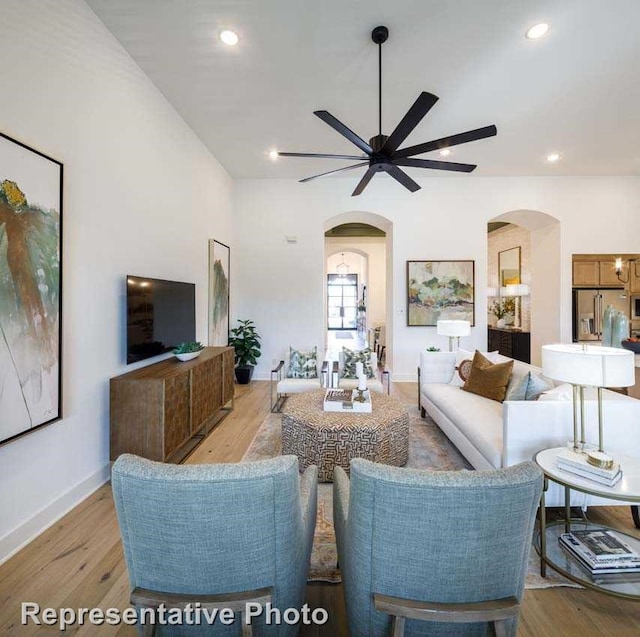 1409 Sire Ct, Aubrey, TX 76227 - living room featuring arched walkways, ceiling fan, light wood-type flooring, recessed lighting, and baseboards