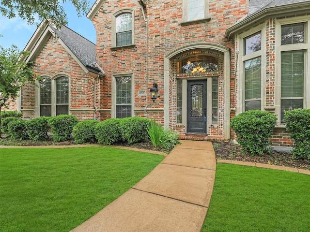 6769 Canal Ct, Grand Prairie, TX 75054 - entrance to property featuring a lawn, brick siding, and a shingled roof
