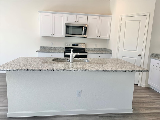 2617 Silver Leaf Ln, Anna, TX 75409 - kitchen featuring appliances with stainless steel finishes, dark wood-style flooring, a center island with sink, and white cabinetry