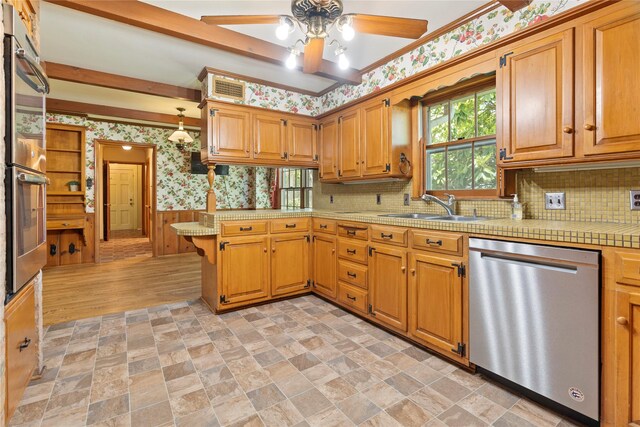 214 Country Club Rd, Hillsboro, TX 76645 - kitchen with stainless steel appliances, wallpapered walls, a sink, light countertops, and a ceiling fan