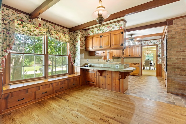 214 Country Club Rd, Hillsboro, TX 76645 - kitchen featuring beamed ceiling, a peninsula, a sink, healthy amount of natural light, and brown cabinets