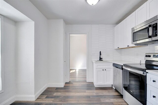 4363 Lisbon St, Fort Worth, TX 76107 - kitchen with appliances with stainless steel finishes, a sink, backsplash, light countertops, and wood finished floors