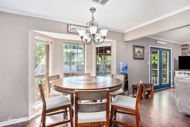 dining area with a chandelier, wood finished floors, and crown molding