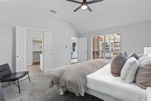 bedroom with vaulted ceiling, light colored carpet, a ceiling fan, baseboards, and a spacious closet