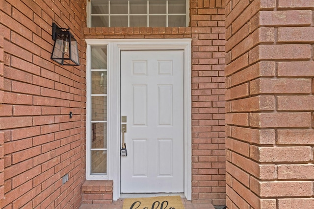 view of exterior entry with brick siding