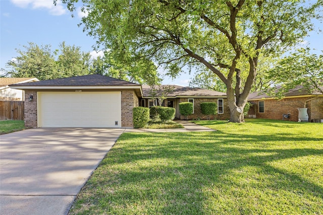 single story home with brick siding, a garage, and driveway