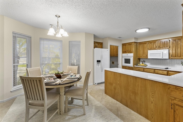 kitchen featuring white appliances, light tile patterned flooring, plenty of natural light, and a textured ceiling