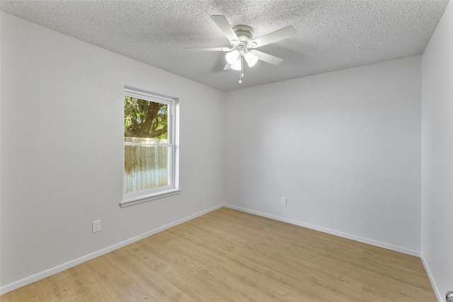 empty room featuring light wood-style flooring, a ceiling fan, a textured ceiling, and baseboards