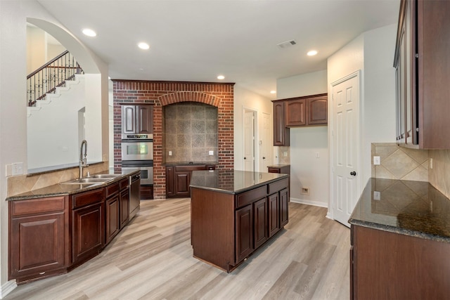 10101 Waterview Pkwy, Rowlett, TX 75089 - kitchen with a sink, stainless steel double oven, light wood finished floors, dark stone counters, and recessed lighting