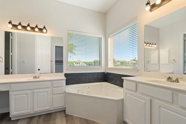 10101 Waterview Pkwy, Rowlett, TX 75089 - full bathroom with healthy amount of natural light, a tub with jets, wood finished floors, and two vanities