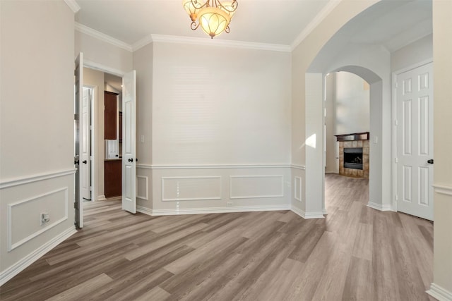 10101 Waterview Pkwy, Rowlett, TX 75089 - spare room featuring wood finished floors, arched walkways, crown molding, a wainscoted wall, and a decorative wall