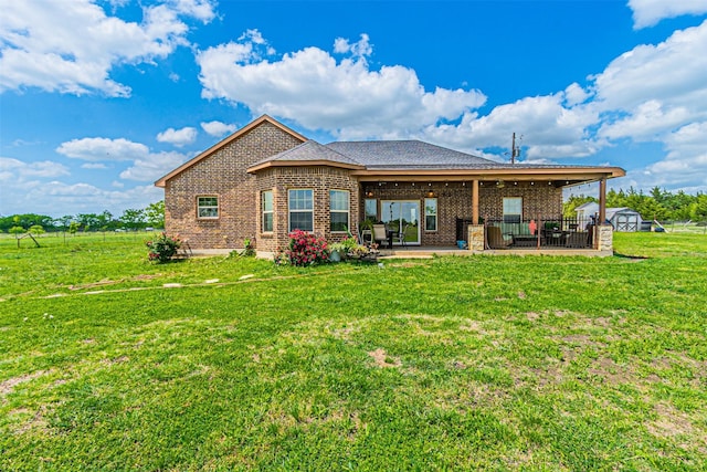 back of property with a patio, brick siding, a shed, a lawn, and an outdoor structure
