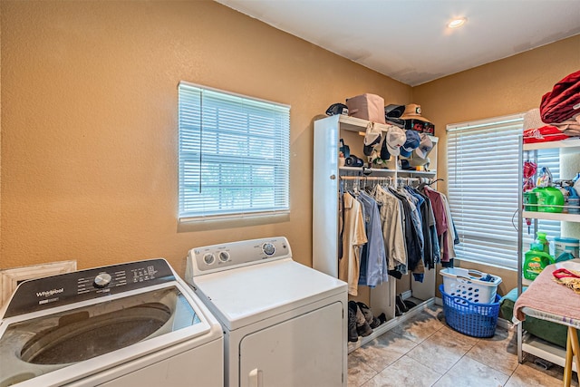 washroom with washing machine and clothes dryer, a textured wall, and light tile patterned floors