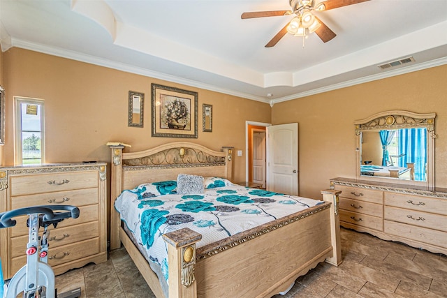 bedroom featuring a raised ceiling, crown molding, a ceiling fan, and light stone finish floors