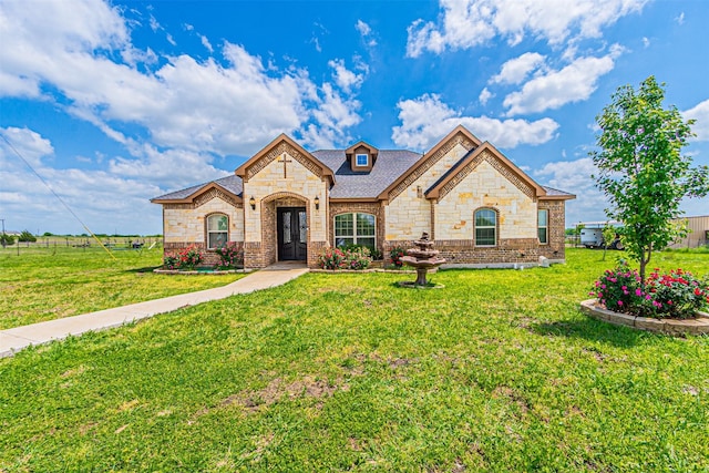 french country style house featuring stone siding, french doors, brick siding, and roof with shingles