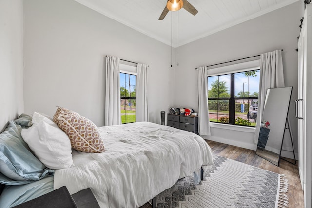 608 N Belknap, Stephenville, TX 76401 - bedroom featuring crown molding, a barn door, wood finished floors, baseboards, and ceiling fan