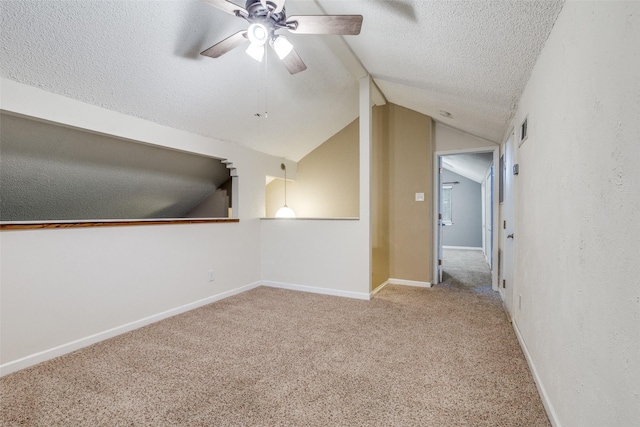 410 Lone Oak Cir, Euless, TX 76039 - empty room with a textured ceiling, a ceiling fan, lofted ceiling, carpet flooring, and baseboards
