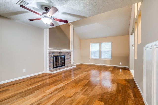 410 Lone Oak Cir, Euless, TX 76039 - unfurnished living room featuring wood finished floors, a ceiling fan, a brick fireplace, a textured ceiling, and baseboards