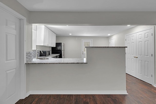 2709 Sarah St, Waco, TX 76706 - kitchen with stainless steel appliances, light stone countertops, white cabinets, backsplash, and recessed lighting