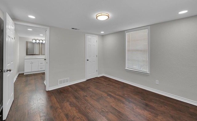 2709 Sarah St, Waco, TX 76706 - unfurnished bedroom featuring dark wood-type flooring, baseboards, recessed lighting, and connected bathroom