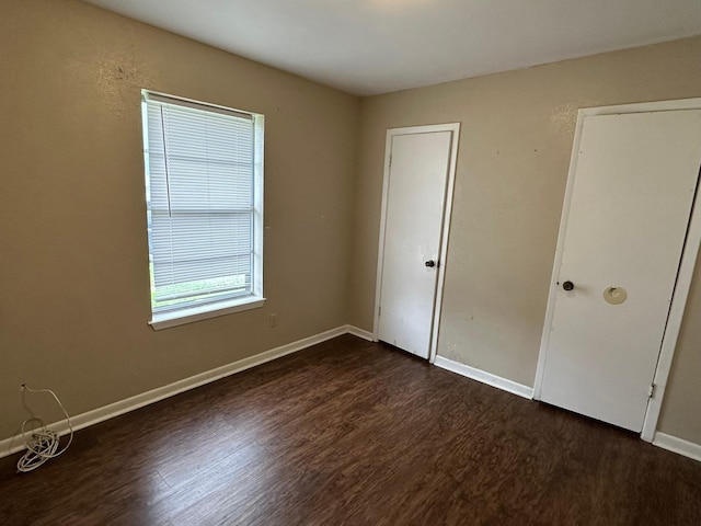 204 Austin Ave, Corsicana, TX 75110 - unfurnished bedroom featuring dark wood-type flooring and baseboards