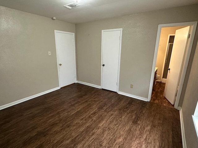 204 Austin Ave, Corsicana, TX 75110 - unfurnished bedroom with dark wood finished floors and baseboards