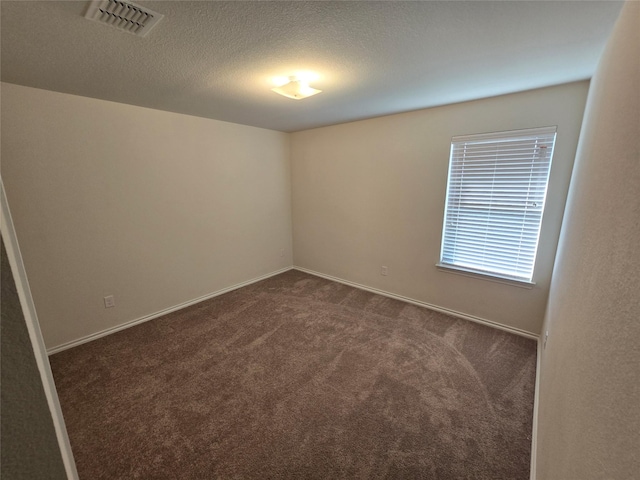 556 Pleasant Park Dr, Wilmer, TX 75172 - empty room with dark carpet, baseboards, and a textured ceiling