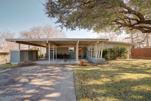 view of front of home with driveway, an outdoor structure, a shed, and a carport