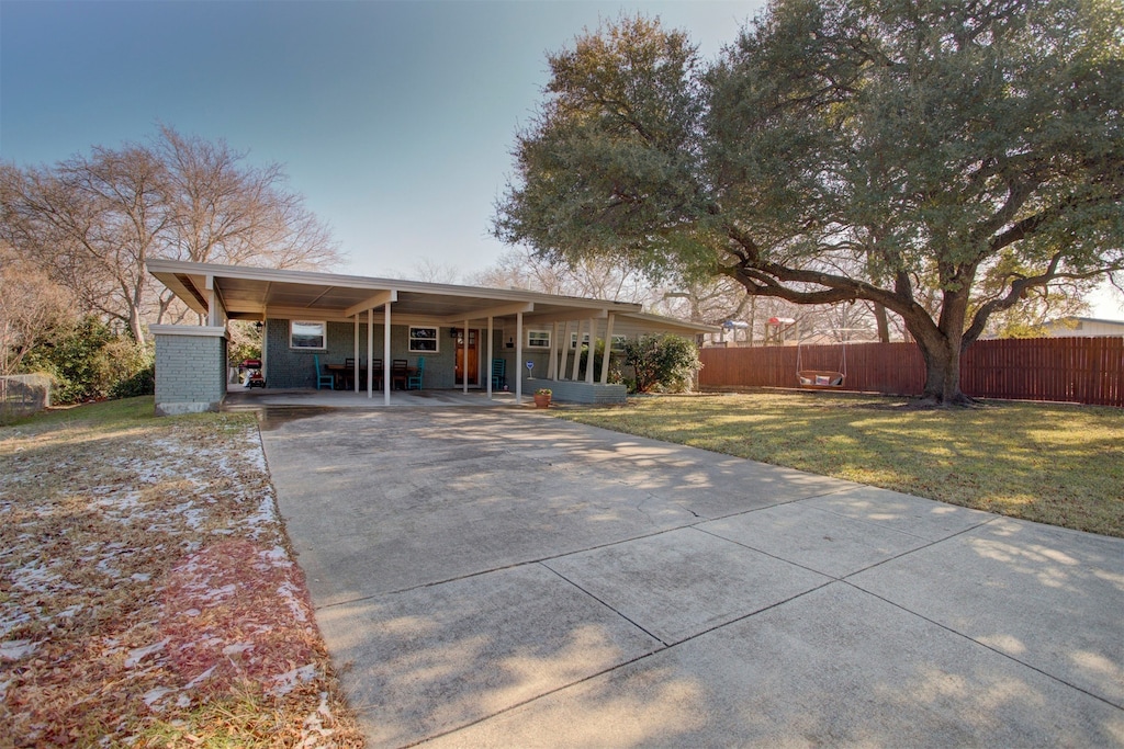 ranch-style house featuring concrete driveway and an attached carport
