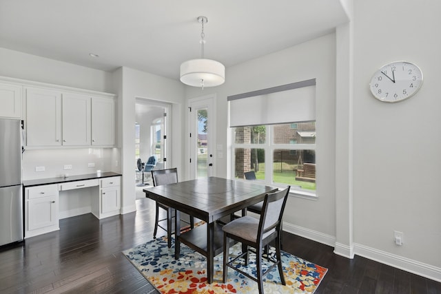 dining space featuring dark wood finished floors, healthy amount of natural light, and baseboards
