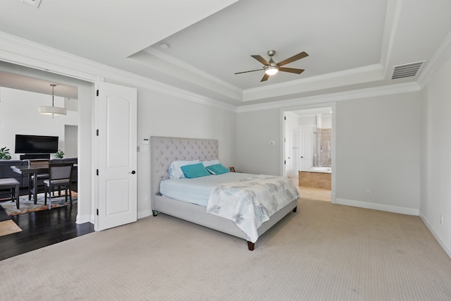 carpeted bedroom with a tray ceiling, ornamental molding, baseboards, and ceiling fan