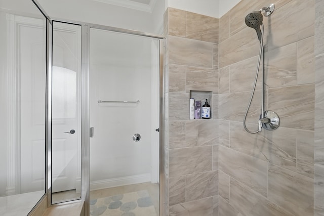 bathroom with a shower stall and crown molding