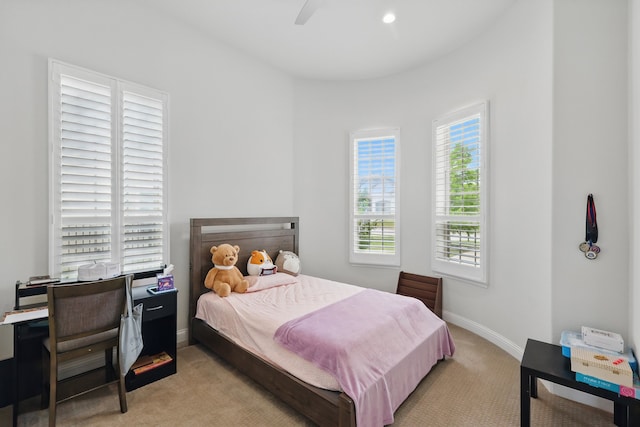bedroom with light colored carpet, baseboards, and a ceiling fan