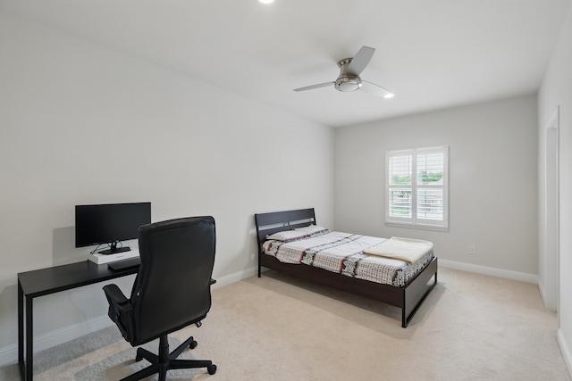 bedroom with light carpet, baseboards, a desk, and a ceiling fan
