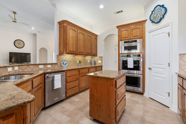 11109 Brook Green Ln, Haslet, TX 76052 - kitchen with appliances with stainless steel finishes, crown molding, backsplash, a ceiling fan, and stone counters