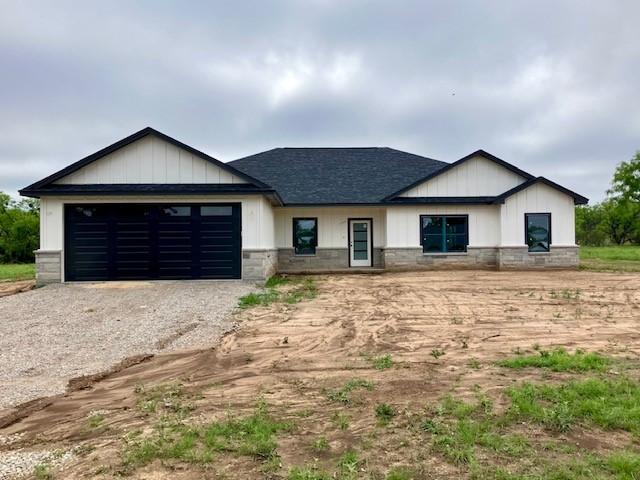 122 Vick, Brownwood, TX 76801 - view of front of property featuring driveway, an attached garage, roof with shingles, and stone siding