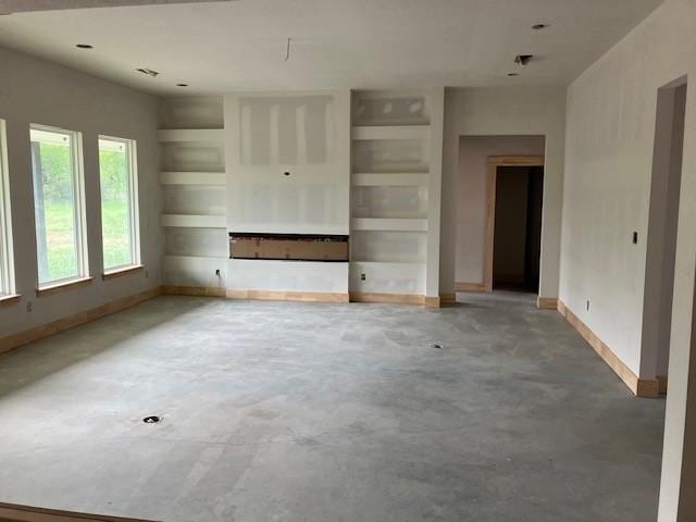 122 Vick, Brownwood, TX 76801 - unfurnished living room featuring concrete floors and baseboards