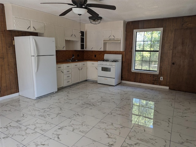 11728 Fm 1399, Marietta, TX 75566 - kitchen featuring white appliances, light marble finish floors, wooden walls, baseboards, and ceiling fan