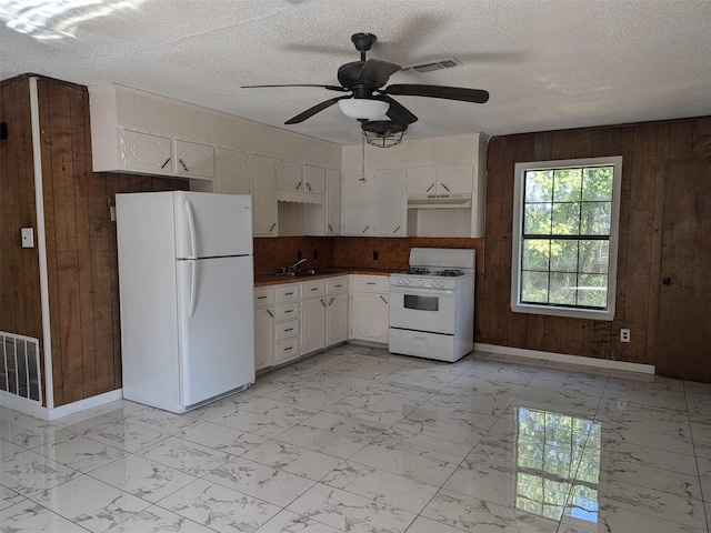11728 Fm 1399, Marietta, TX 75566 - kitchen with white appliances, wooden walls, light marble finish flooring, baseboards, and under cabinet range hood