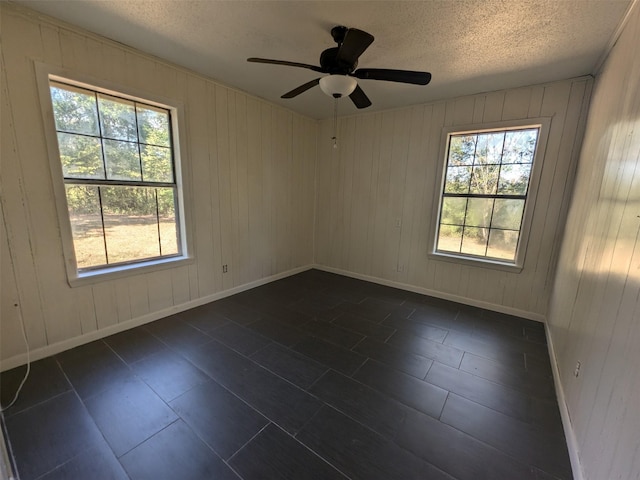 11728 Fm 1399, Marietta, TX 75566 - spare room with a textured ceiling, a ceiling fan, baseboards, and wooden walls