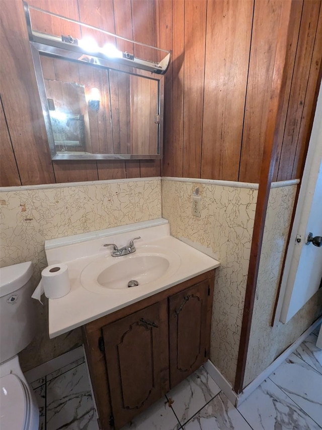 11728 Fm 1399, Marietta, TX 75566 - bathroom featuring marble look tiles, toilet, vanity, and wood walls