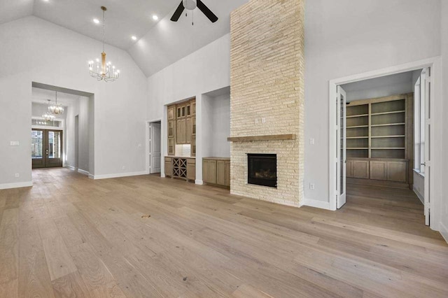 4316 Sandbrock Pkwy, Aubrey, TX 76227 - unfurnished living room with a chandelier, ceiling fan, high vaulted ceiling, a stone fireplace, and light wood finished floors