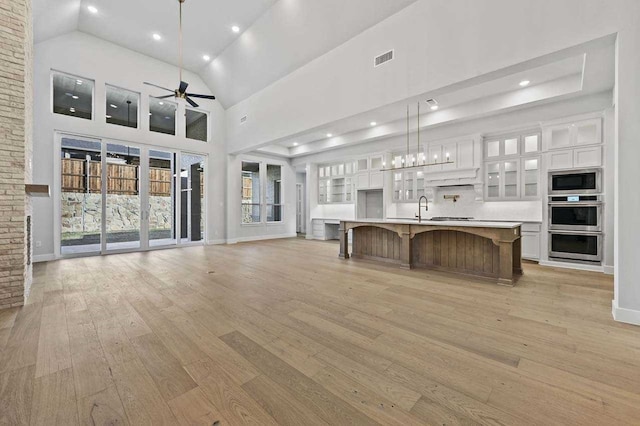 4316 Sandbrock Pkwy, Aubrey, TX 76227 - kitchen featuring ceiling fan, stainless steel appliances, white cabinetry, light wood-style floors, and high vaulted ceiling